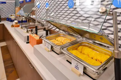 a buffet line with trays of food on display at Holiday Inn Express & Suites Miami Kendall by IHG in Kendall