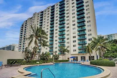 a large building with a swimming pool in front of a building at Luxury Beachfront Apartments 4001 S Ocean Dr in Hollywood