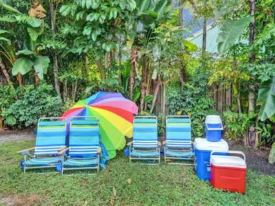 a group of chairs and an umbrella and water containers at Vidal Manor in Fort Lauderdale