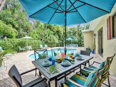a table with a blue umbrella on a patio at Vidal Manor in Fort Lauderdale