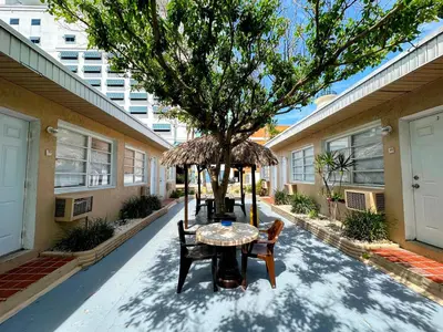 a table and chairs under a tree in a courtyard at St Maurice Beach Inn in Hollywood