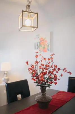a vase with red flowers sitting on a table at 2 Bedroom 2 Bath With Patio On 11th Collins ave in Miami Beach