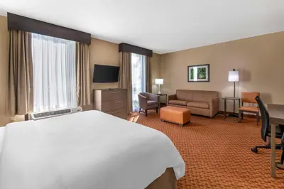 a hotel room with a bed and a living room at Best Western Plus Kendall Hotel & Suites in Kendall