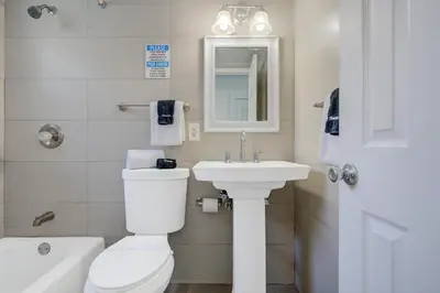 a bathroom with a white toilet and a sink at Leeward Motel By Capital O North Miami Beachside in North Miami