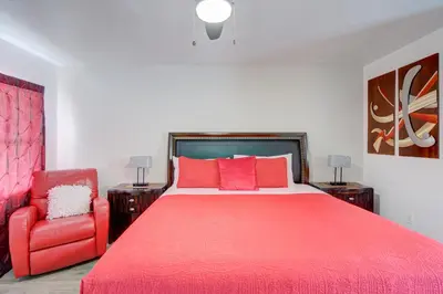a bedroom with a red bed and a red chair at Leeward Motel By Capital O North Miami Beachside in North Miami