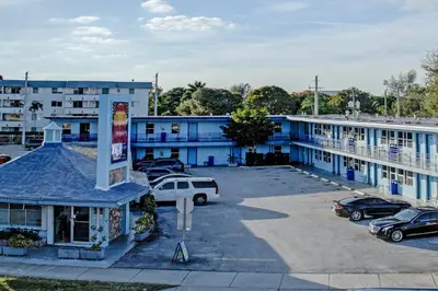 a blue building with cars parked in a parking lot at Leeward Motel By Capital O North Miami Beachside in North Miami