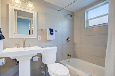 a bathroom with a sink and a toilet and a tub at Leeward Motel By Capital O North Miami Beachside in North Miami