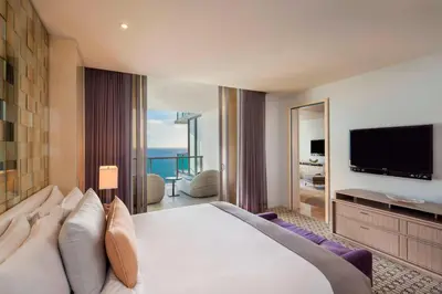 a hotel room with a large bed and a television at The St. Regis Bal Harbour Resort in Miami Beach