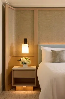 a bedroom with a bed and a nightstand with a lamp at Loews Miami Beach Hotel in Miami Beach