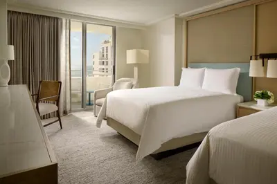 a hotel room with a large bed and a balcony at Loews Miami Beach Hotel in Miami Beach