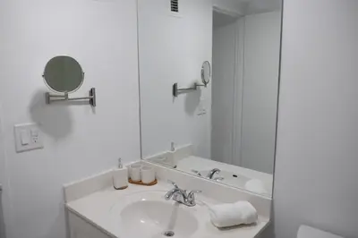a white bathroom with a sink and a mirror at The Tides Miami in Miami