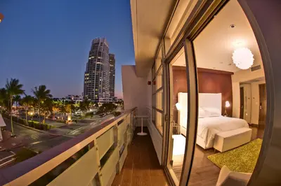 a bedroom with a bed and a view of a city at Prime Hotel Miami in Miami Beach