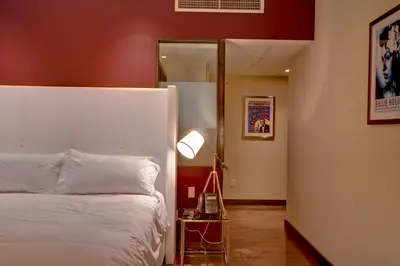 a bedroom with a white bed and a mirror at Prime Hotel Miami in Miami Beach