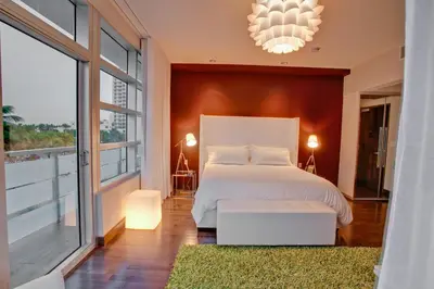 a bedroom with a white bed and a large window at Prime Hotel Miami in Miami Beach