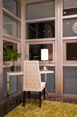 a white chair sitting next to a desk with a lamp at Prime Hotel Miami in Miami Beach