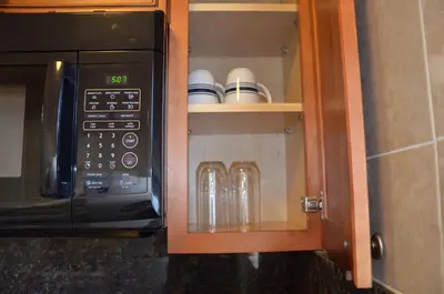 a microwave in a kitchen with some glasses in it at La Terrace Oceanfront in Hollywood