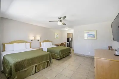 a hotel room with two beds and a flat screen tv at La Terrace Oceanfront in Hollywood