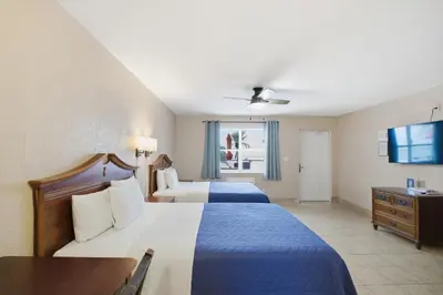 a hotel room with two beds and a television at La Terrace Oceanfront in Hollywood