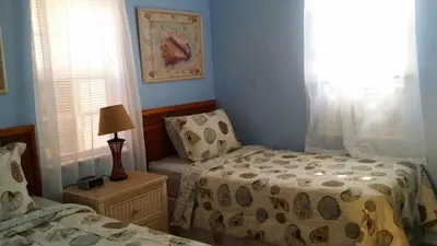 a bedroom with two beds and a chair in it at Atlantic Sands Beach Suites in Hollywood