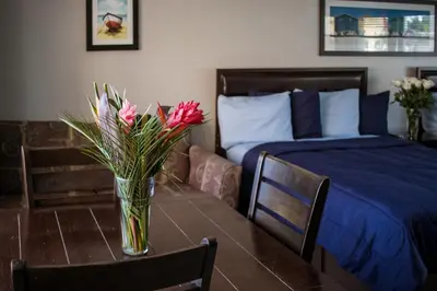 a bedroom with a table with a vase of flowers on it at Riptide Oceanfront Hotel in Hollywood