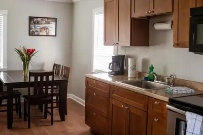 a kitchen with a sink and a table with chairs at Riptide Oceanfront Hotel in Hollywood