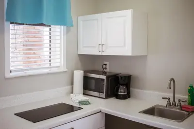 a kitchen with a sink and a microwave at Riptide Oceanfront Hotel in Hollywood