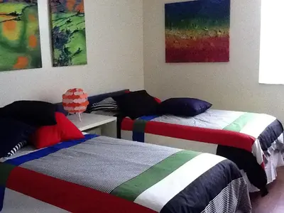 two beds in a room with paintings on the wall at Resort Style In Aventura Florida in Aventura