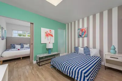 a bedroom with two beds and a striped wall at SoBe Lux Suites On Ocean in Miami Beach