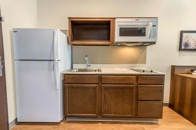 a kitchen with a white refrigerator and a microwave at WoodSpring Suites Miramar in Miramar