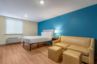 a hospital room with a bed and a couch at WoodSpring Suites Miramar in Miramar
