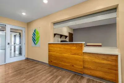 a kitchen with a large wooden cabinet in a room at WoodSpring Suites Miramar in Miramar