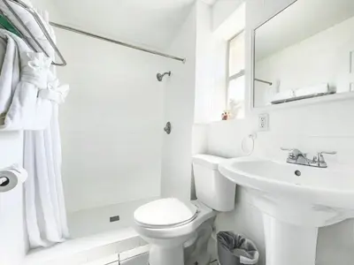 a white bathroom with a toilet and a sink at The Swan in Hollywood