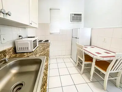 a kitchen with a sink and a table with chairs at The Swan in Hollywood
