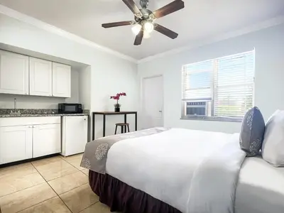 a white bedroom with a bed and a kitchen at The Swan in Hollywood