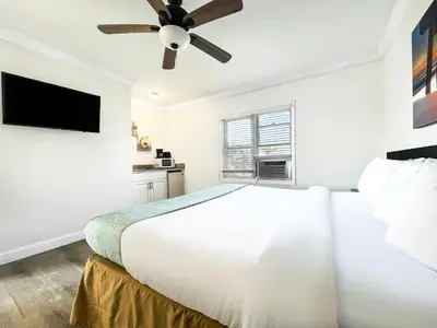 a white bedroom with a bed and a ceiling fan at The Seagull in Hollywood
