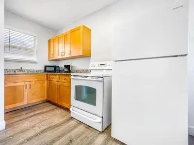 a kitchen with a white refrigerator and wooden cabinets at Hollywood Beach Seaside in Hollywood