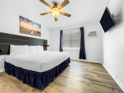 a bedroom with a bed and a ceiling fan at Hollywood Beach Seaside in Hollywood