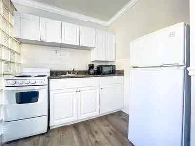 a kitchen with white cabinets and a white refrigerator at Hollywood Beach Seaside in Hollywood