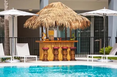 a bar with stools next to a swimming pool at Le Meridien Dania Beach at Fort Lauderdale Airport in Dania Beach