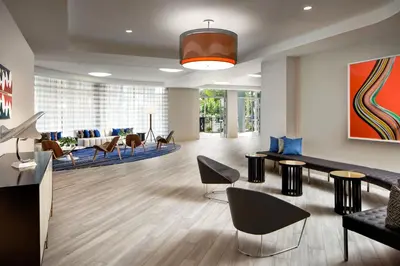 a lobby with a waiting area with chairs and tables at Le Meridien Dania Beach at Fort Lauderdale Airport in Dania Beach
