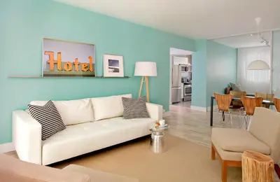 a living room with a white couch and a dining room at 1818 Meridian House Apartments and Suites by Eskape Collection in Miami Beach