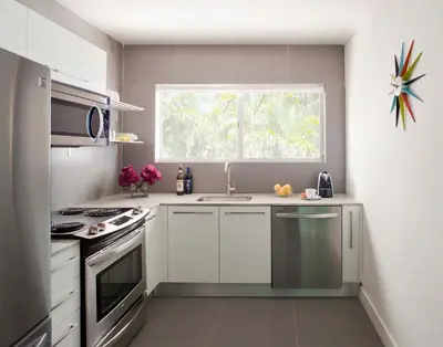 a white kitchen with a sink and a window at 1818 Meridian House Apartments and Suites by Eskape Collection in Miami Beach