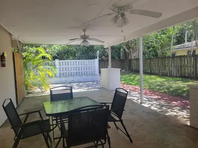 a patio with a table and chairs and a ceiling fan at Apts with Backyard Near Fort Lauderdale Beach, Nightlife, Cruise Port, Airport in Fort Lauderdale