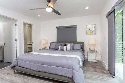 a bedroom with a large bed and two lamps at CASA HERMÈS Wilton Manor - Gay Guesthouse in Fort Lauderdale