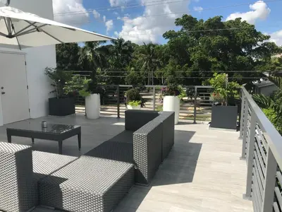 a patio with couches and a table at CASA HERMÈS Wilton Manor - Gay Guesthouse in Fort Lauderdale