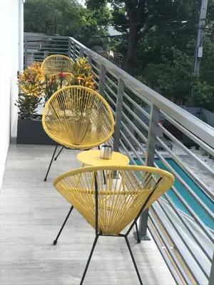two yellow chairs and a table on a balcony at CASA HERMÈS Wilton Manor - Gay Guesthouse in Fort Lauderdale