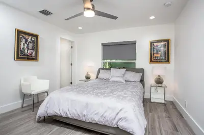 a bedroom with a bed and a ceiling fan at CASA HERMÈS Wilton Manor - Gay Guesthouse in Fort Lauderdale