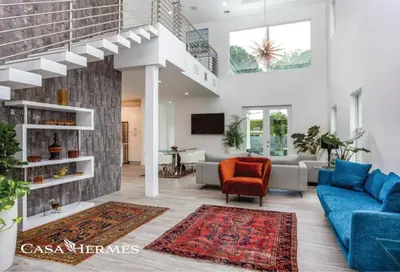 a living room with a blue couch and a red chair at CASA HERMÈS Wilton Manor - Gay Guesthouse in Fort Lauderdale