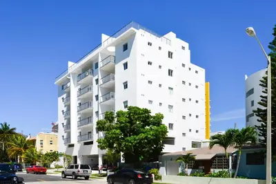 a white building with cars parked in front of it at Amazing 2 BR Condo At Wynwood With Parking in Miami