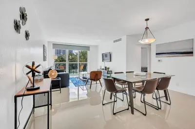 a dining room and living room with a table and chairs at The Tides Apartments on the beach in Hollywood